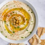 Hummus served in a bowl with pita chips on the side