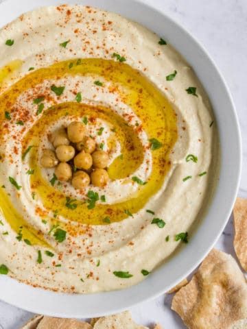 Hummus served in a bowl with pita chips on the side