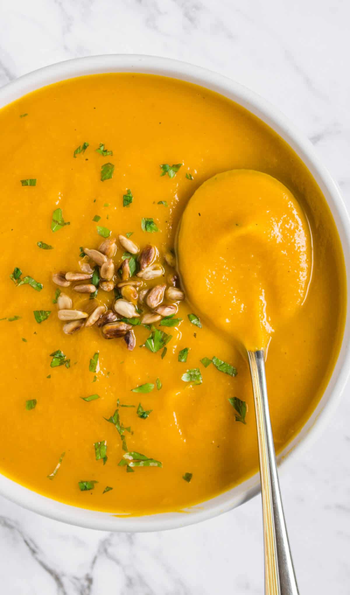 Pumpkin soup close up with a spoon 