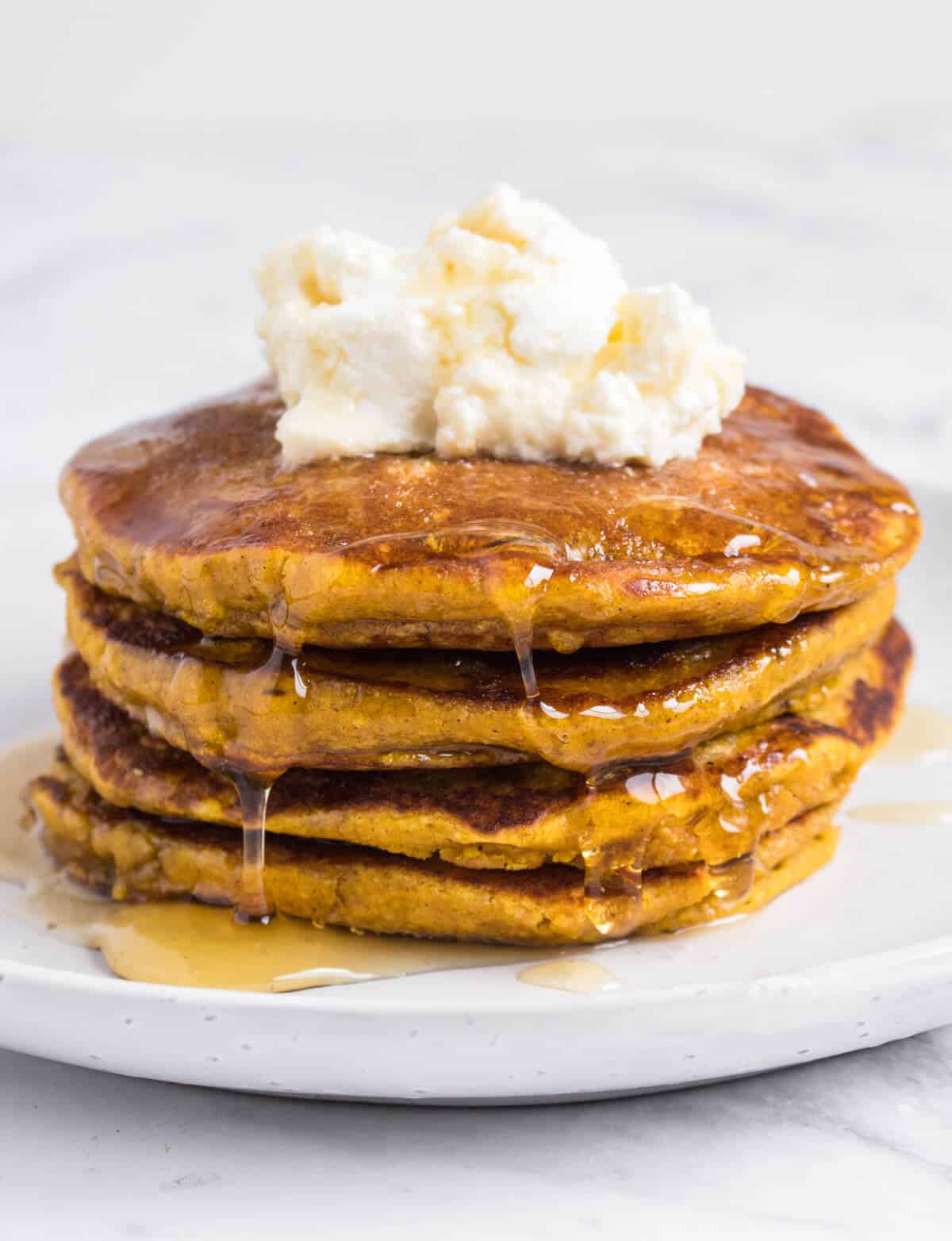 Pumpkin pancakes topped with ricotta and syrup