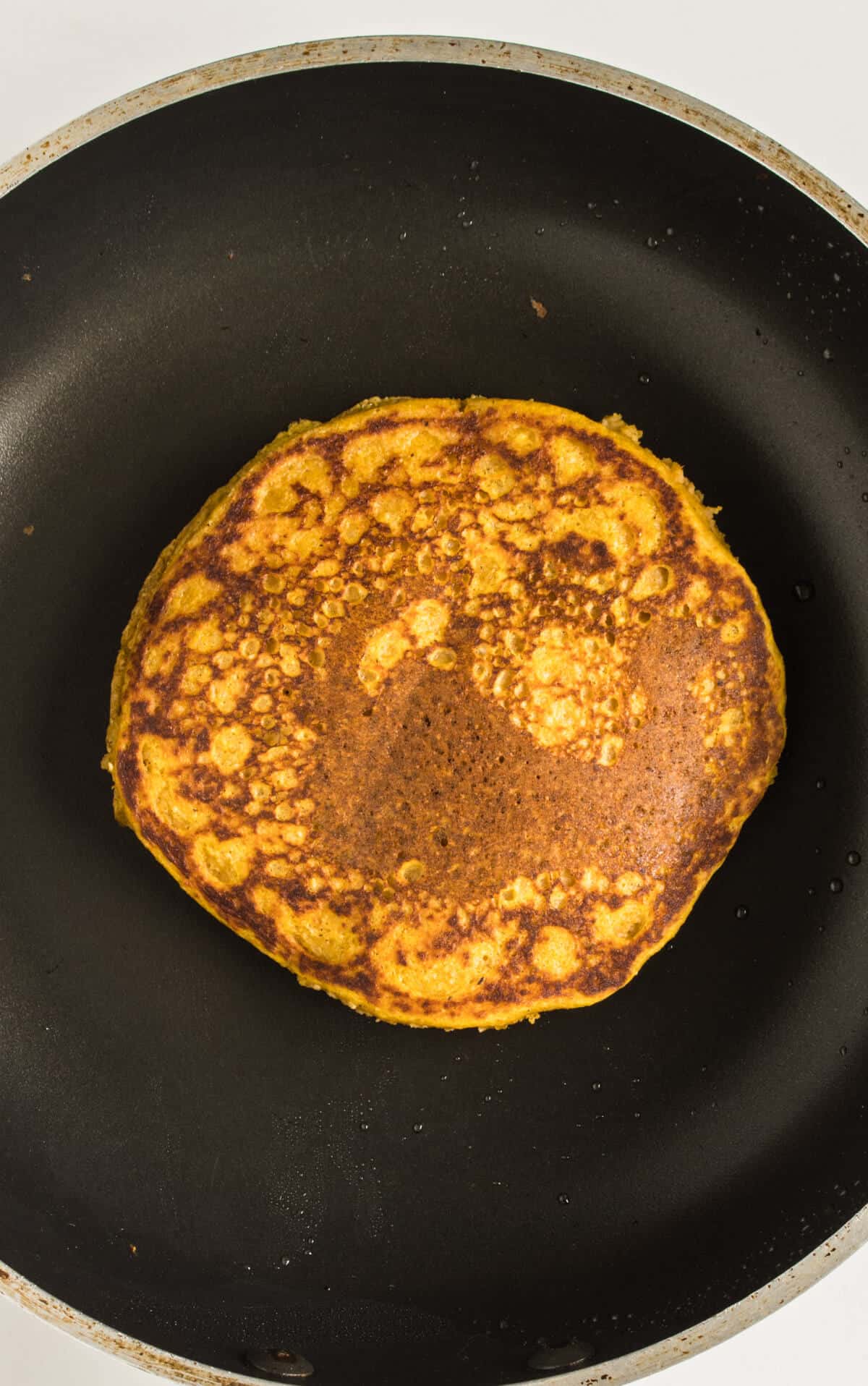 Pumpkin pancake cooking on a pan