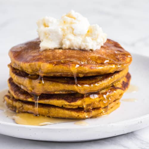 Pumpkin Pancakes topped with ricotta and drizzled with syrup