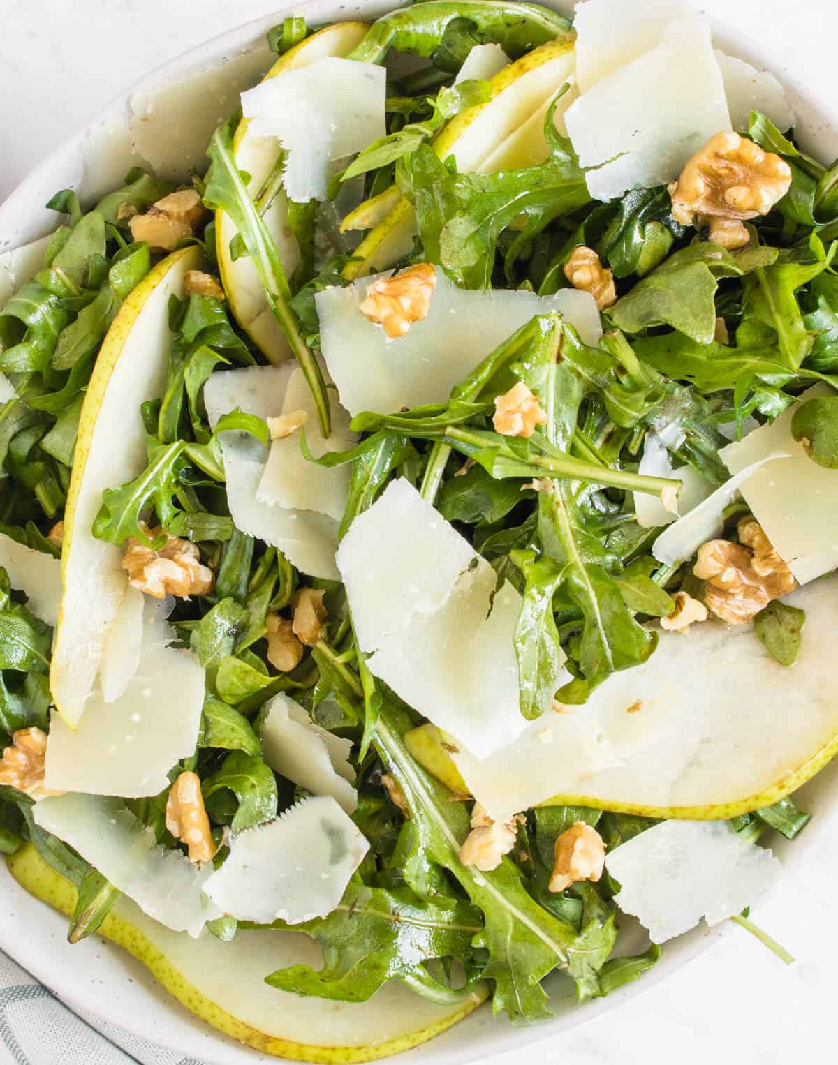 Close up shot of the rocket, pear and parmesan salad served in a bowl