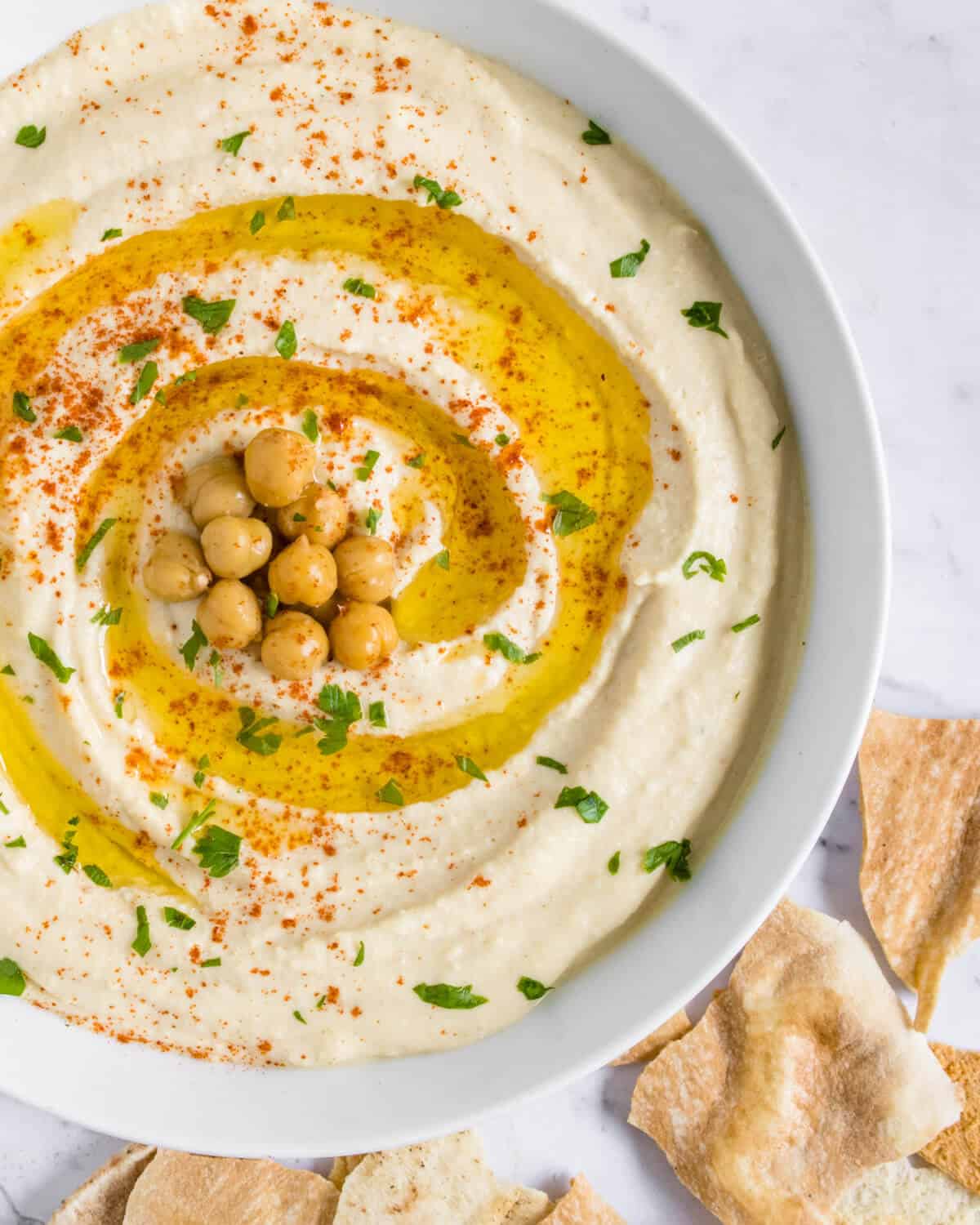 Hummus served in a bowl with pita chips on the side