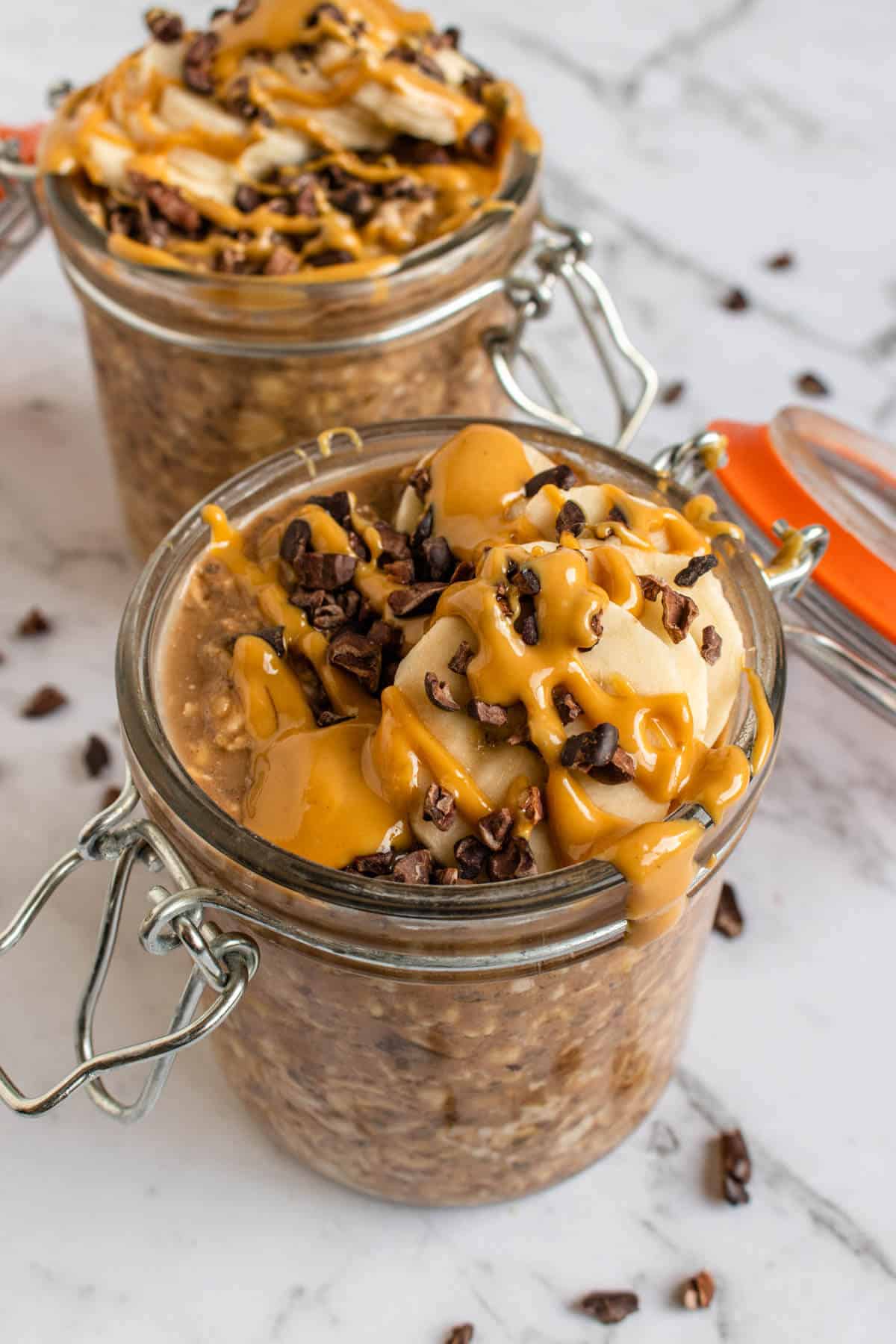 Chocolate Peanut Butter Overnight Oats topped with cacao nibs, banana and peanut butter