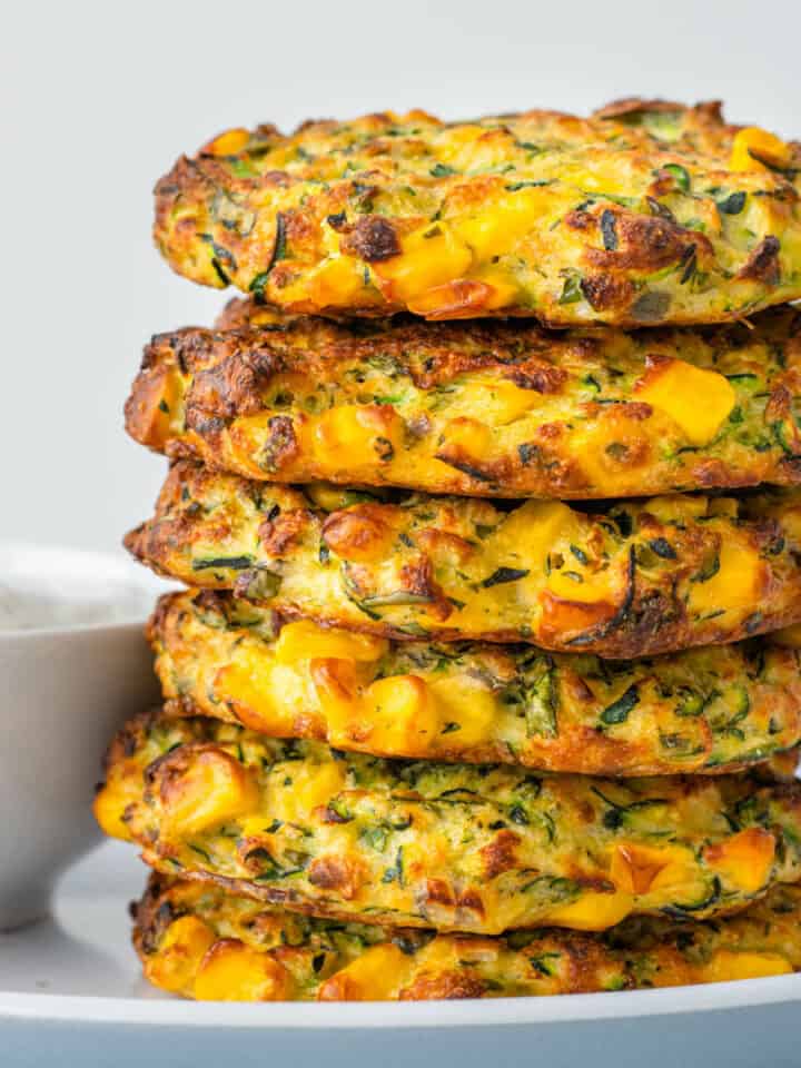 Zucchini Corn Fritters stacked with herbed yoghurt