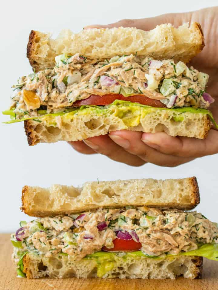 Healthy Tuna Salad sandwich being picked up by hand