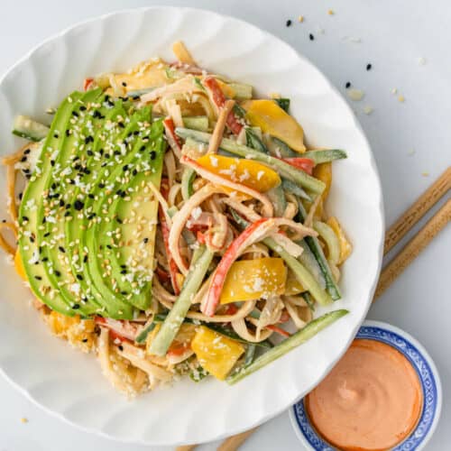 Kani Salad in a bowl topped with avocado, sesame seeds and panko bread crumbs