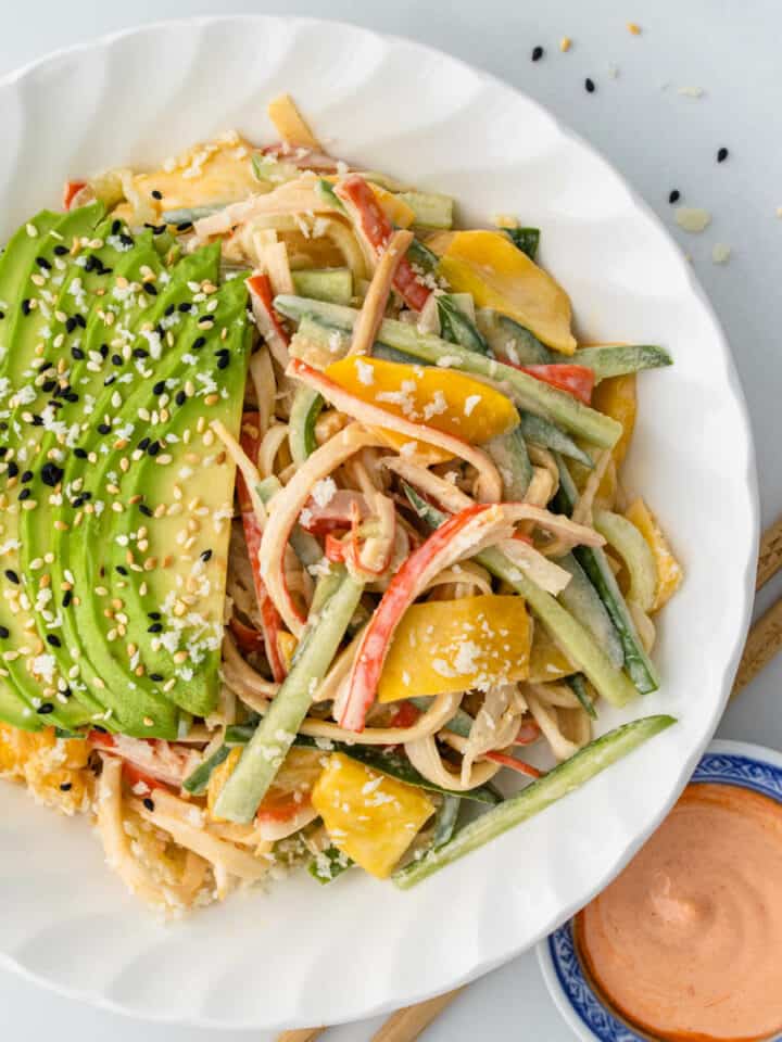 Kani Salad in a bowl topped with avocado, sesame seeds and panko bread crumbs