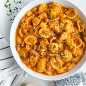 Pasta e Fagioli served in a bowl topped with parsley and parmesan cheese