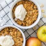 Ramekins of healthy apple crumble topped with a scoop of ice cream