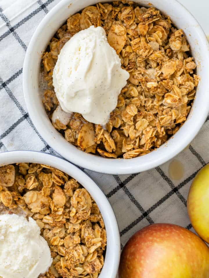 Ramekins of healthy apple crumble topped with a scoop of ice cream