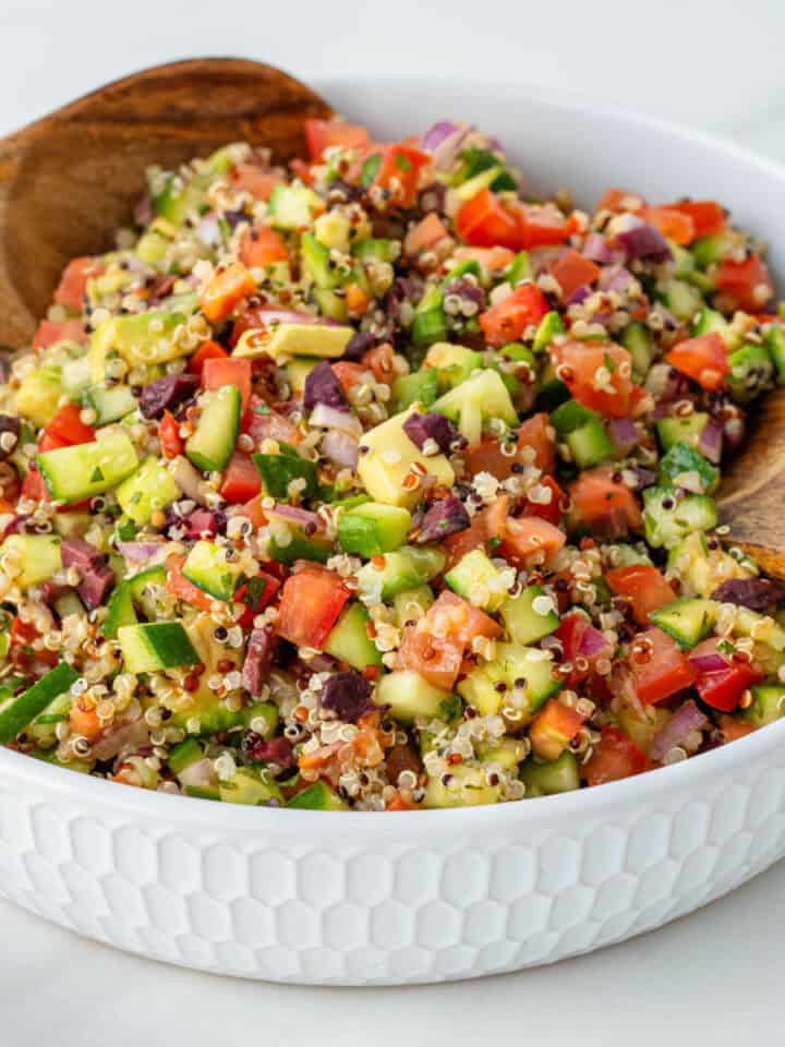 Quinoa salad served in a bowl with mixing spoons