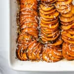 Baked sweet potato slices in an oven dish with grated parmesan on top