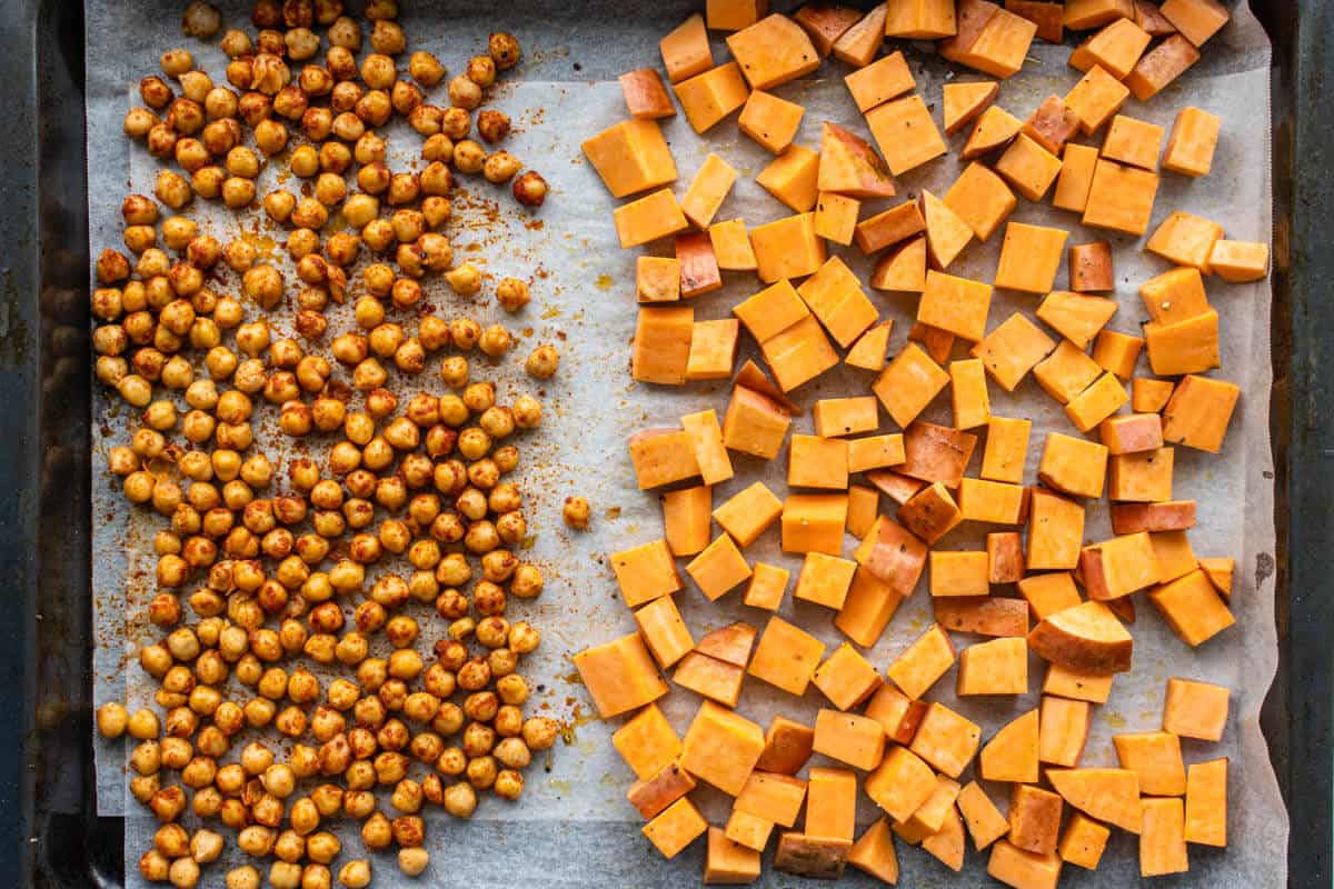 Seasoned chickpeas and diced sweet potatoes on an oven tray