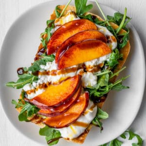 Burrata toast with peach and arugula