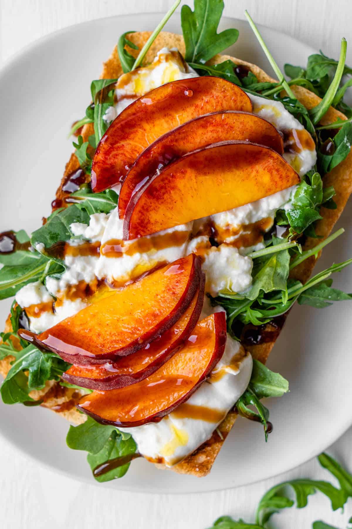 Burrata toast with peach, arugula and balsamic glaze