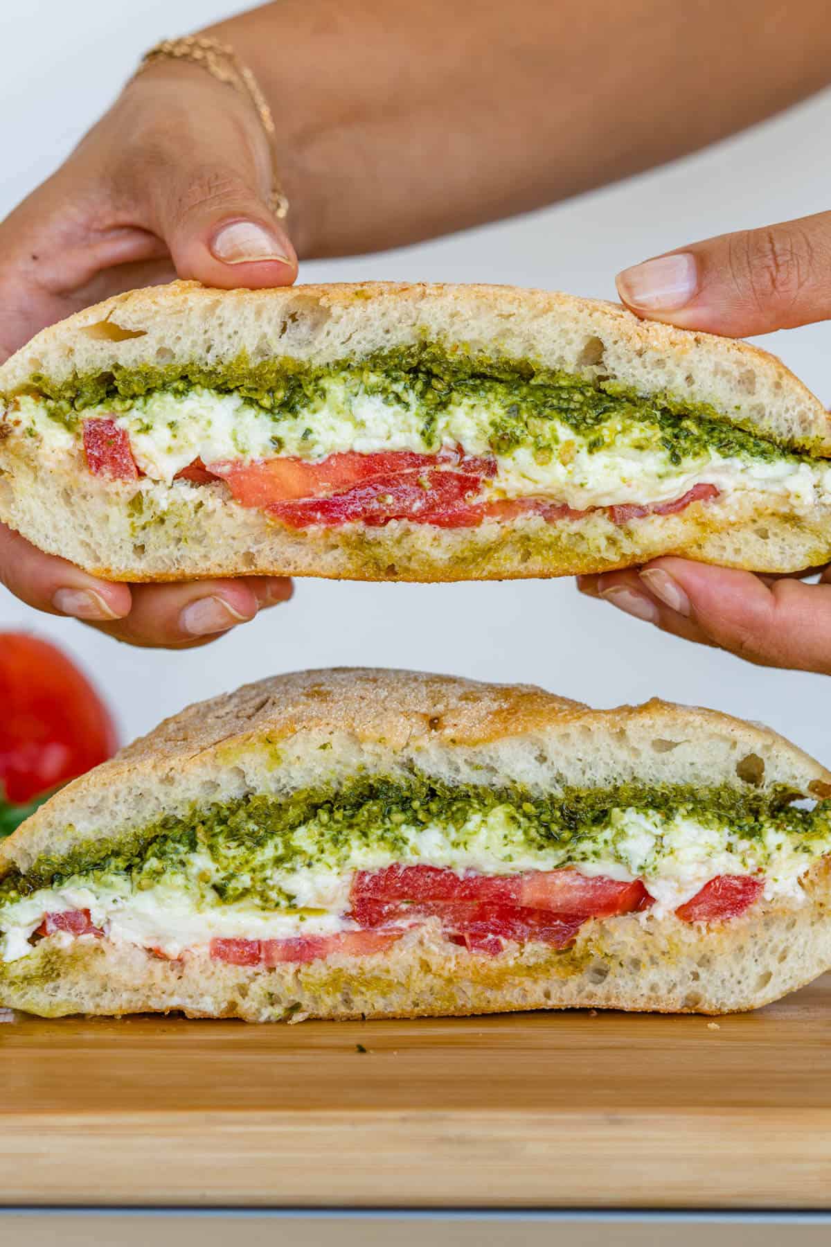 Caprese sandwich with piece being picked up
