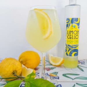 Glass of Limoncello Spritz with lemons and a bottle of limoncello
