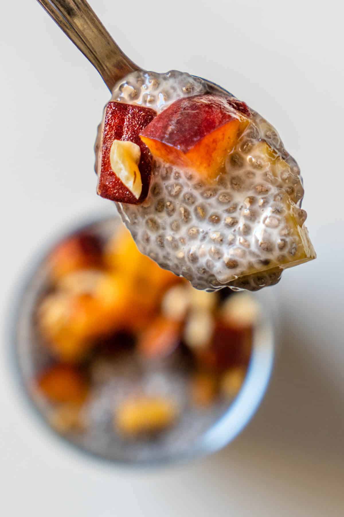 Peach chia pudding on a teaspoon to show creamy texture