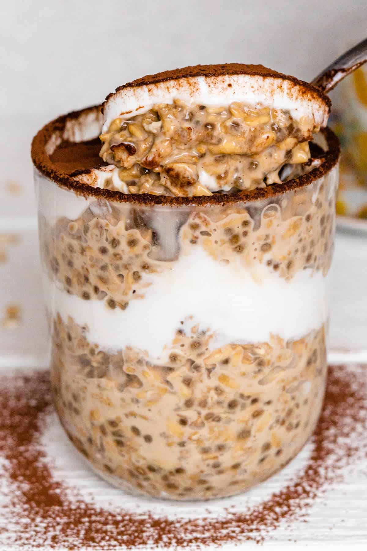 Spoon coming out of the glass of the tiramisu oats