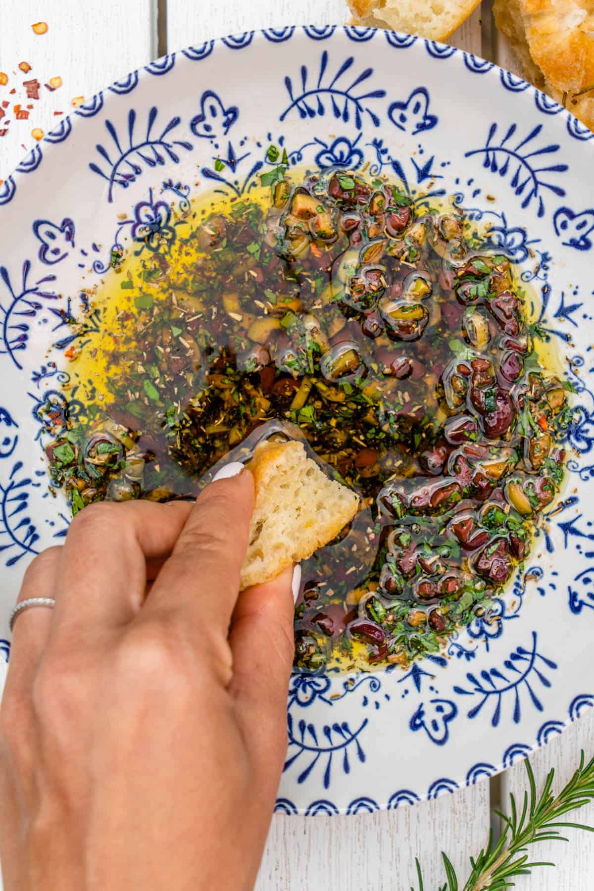 Dipping a piece of bread into a bowl of bread oil