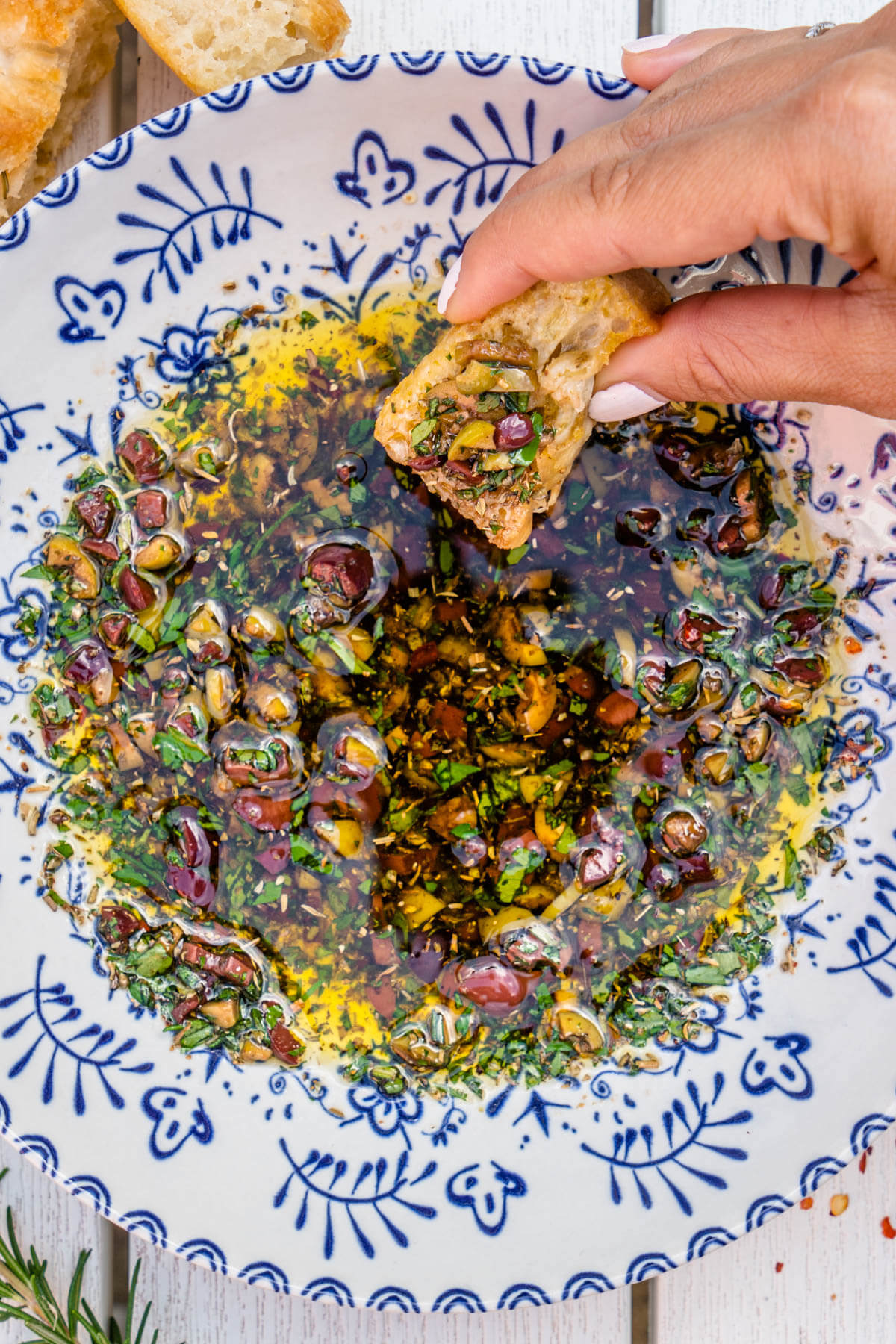 Bread dipping oil being dipped with fresh focaccia bread