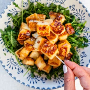 Fried halloumi bites being picked with a toothpick