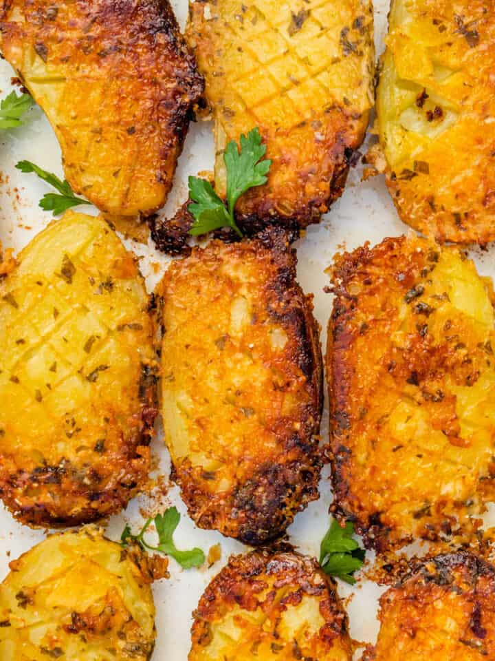 Parmesan crusted potatoes in an oven dish with fresh parsley