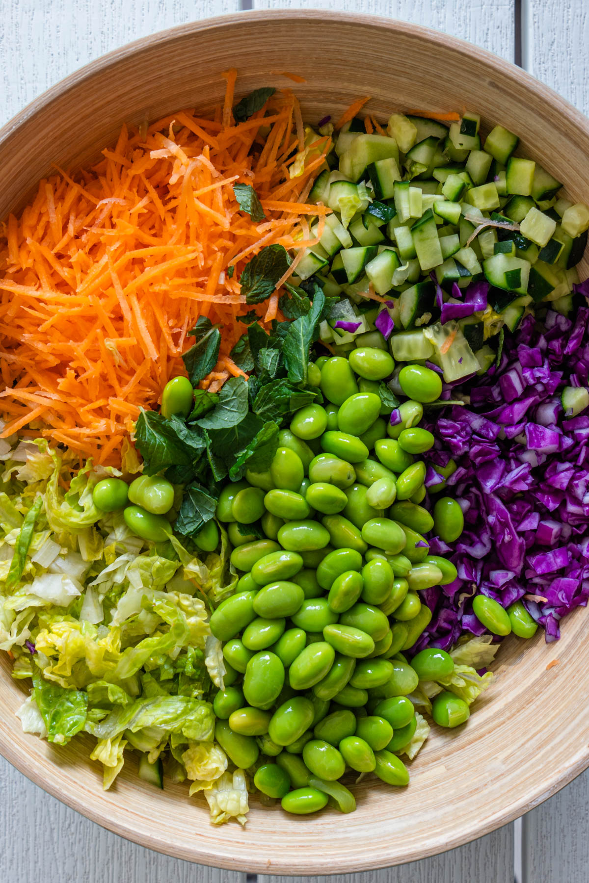 Chopped asian salad ingredients in a bowl before being mixed