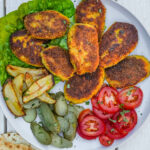 Kotlet Persian Patties served on a plate with tomato, fries and pickles