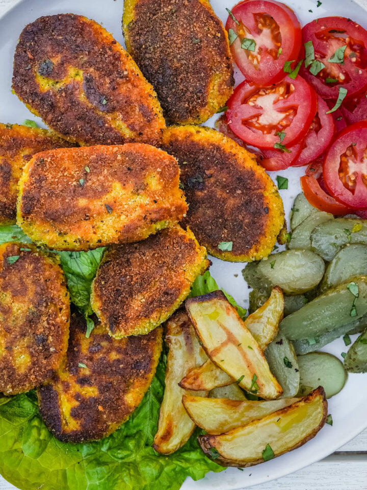 Plate of kotlet Persian patties with tomato, pickles and fries