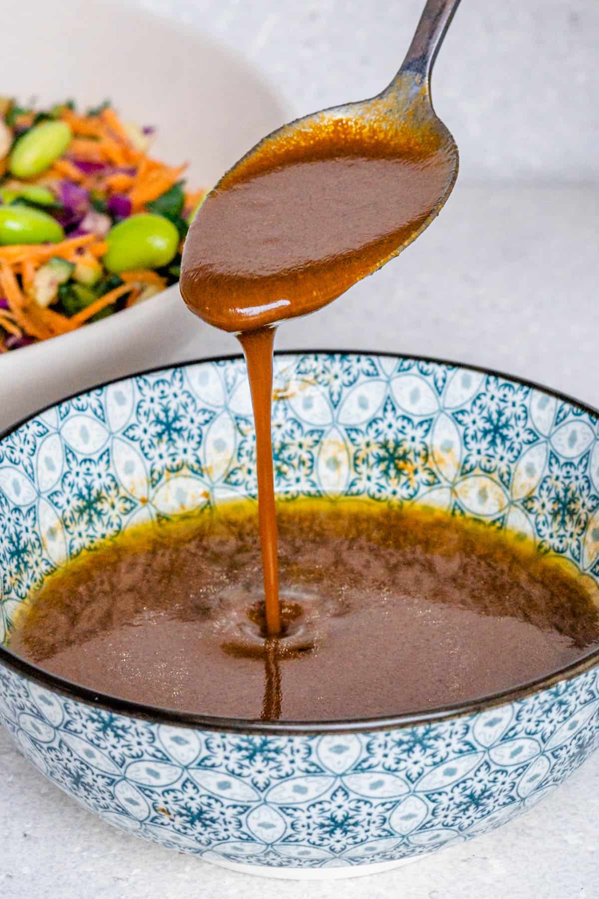 Spoon drizzle of miso ginger dressing into a bowl