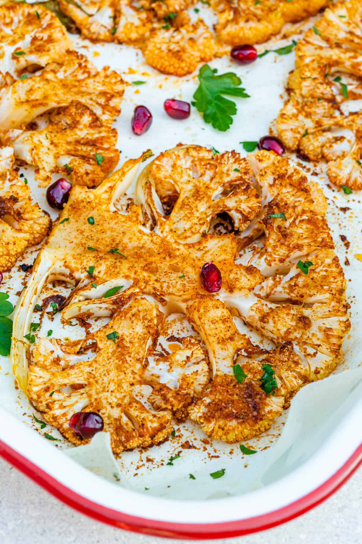 Close up of roasted cauliflower steaks in an oven tray