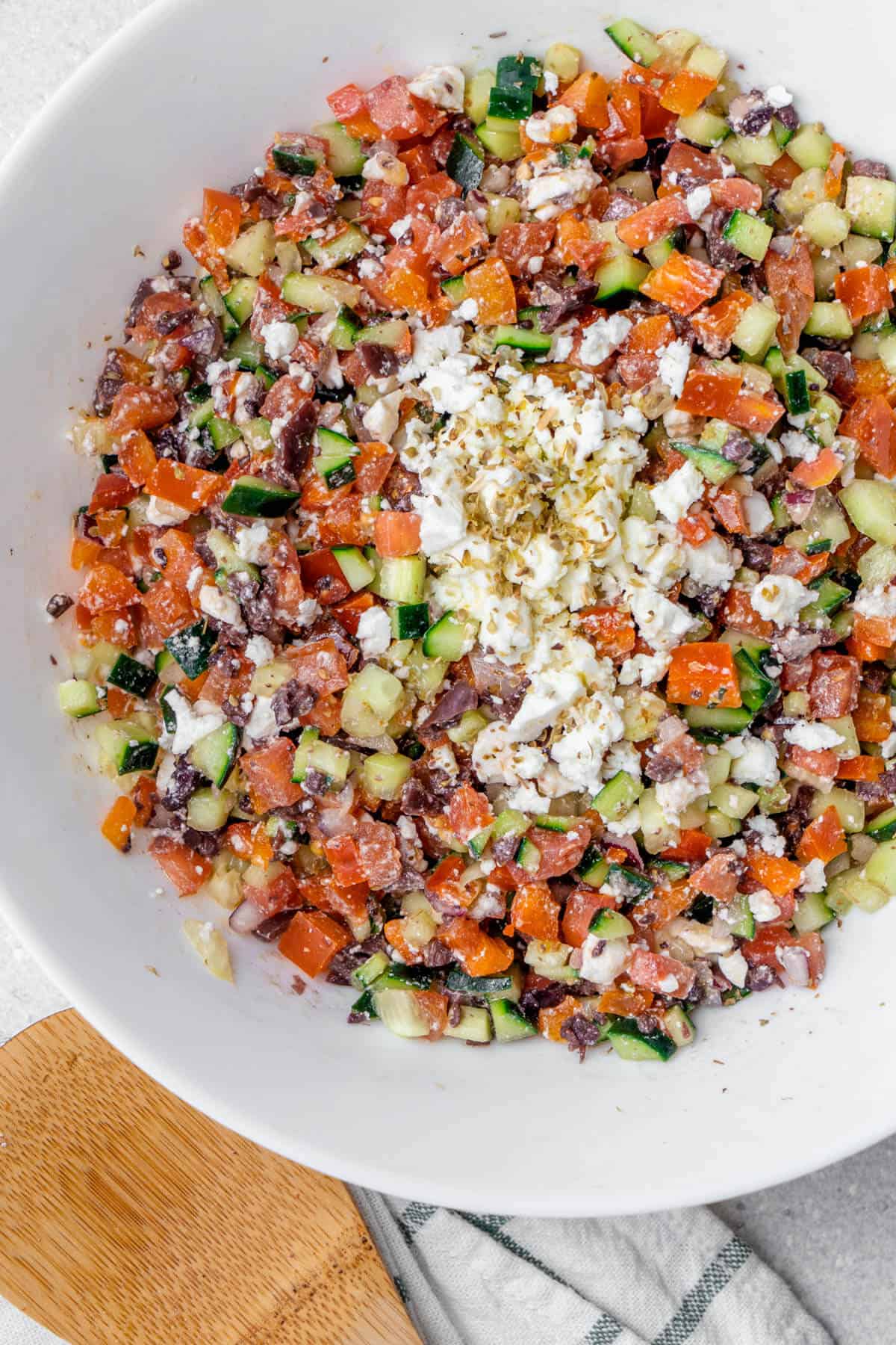 Chopped Greek Salad served in a bowl with serving spoon on the side
