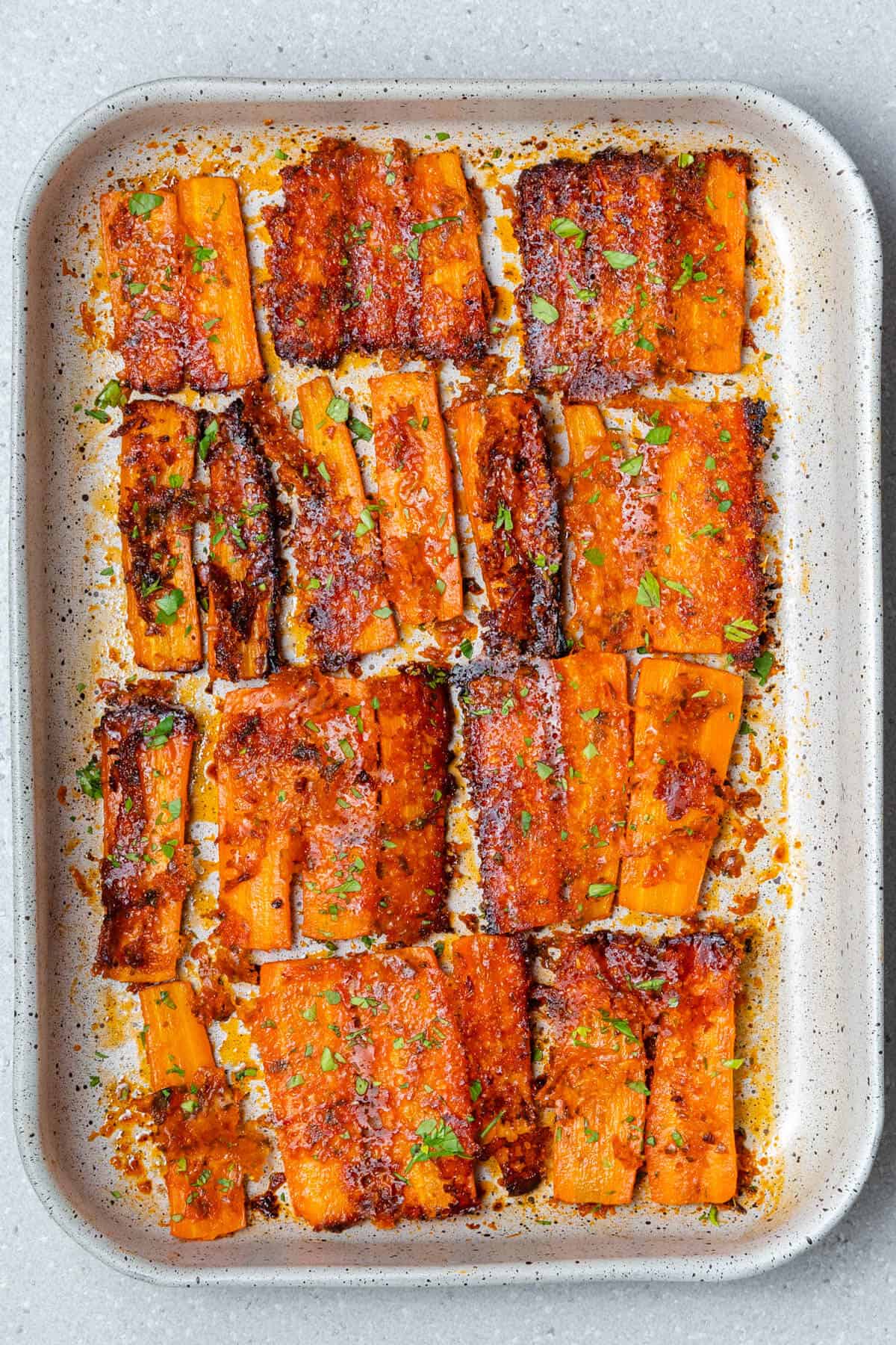 Roasted parmesan carrots flipped in an oven dish to show crust