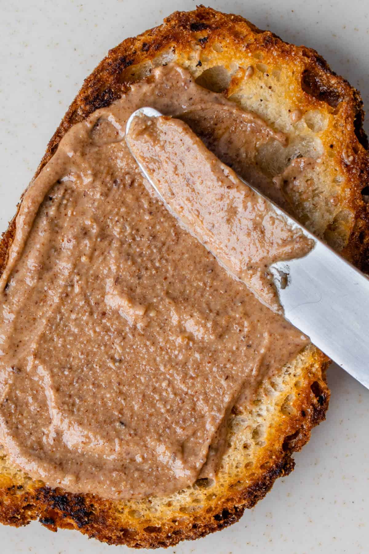 Almond butter being spread on toast