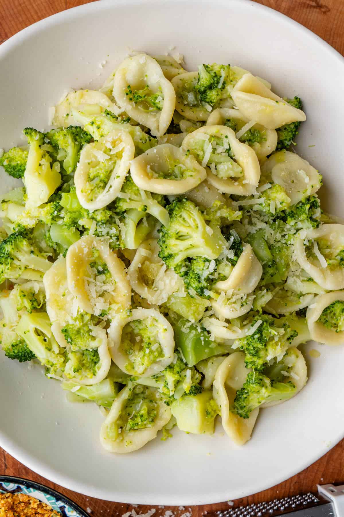 Broccoli pasta served in a bowl with parmesan cheese