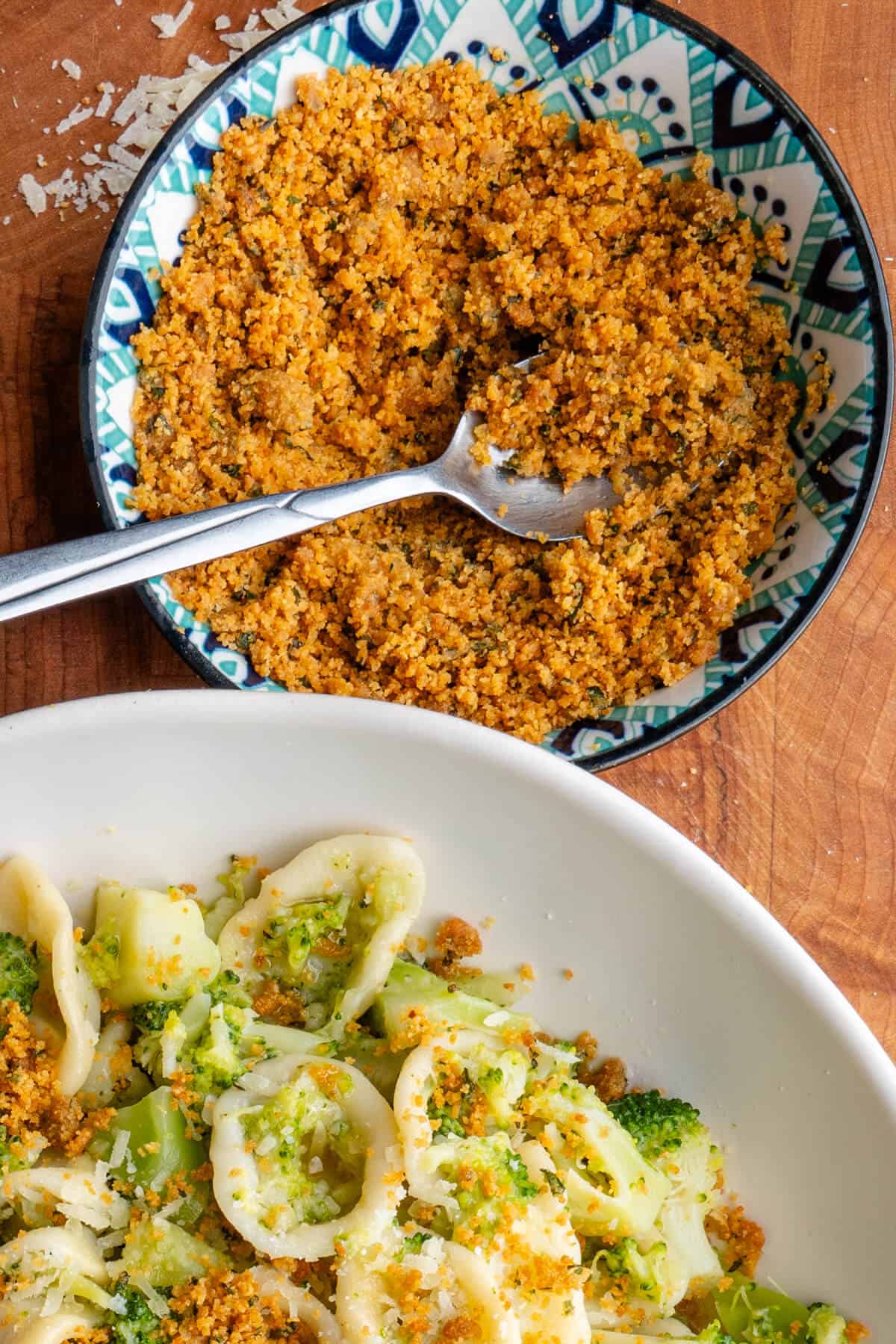 Pangrattato in a bowl that was topped on a bowl of broccoli pasta