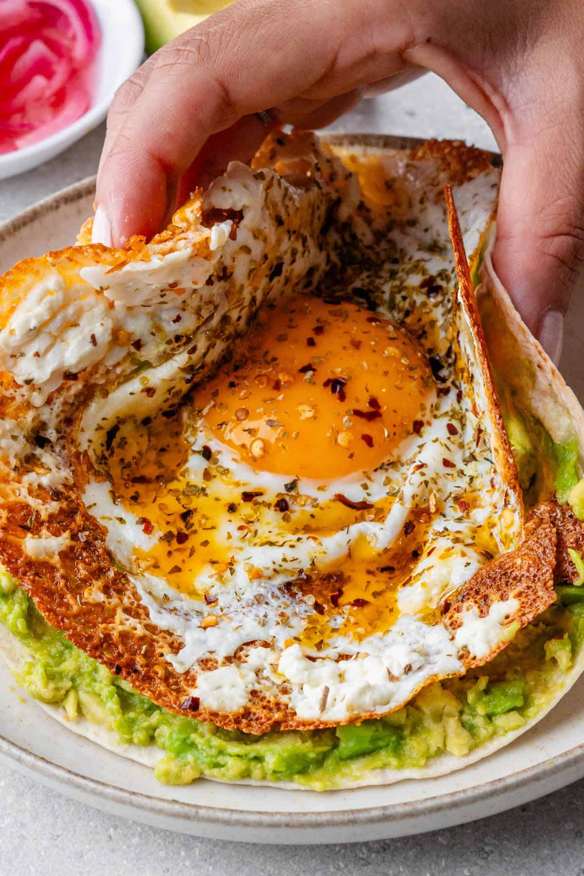 Tortilla with a feta fried egg being picked up