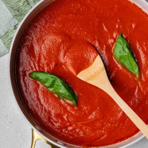 Homemade tomato sauce in a pan with a wooden spoon