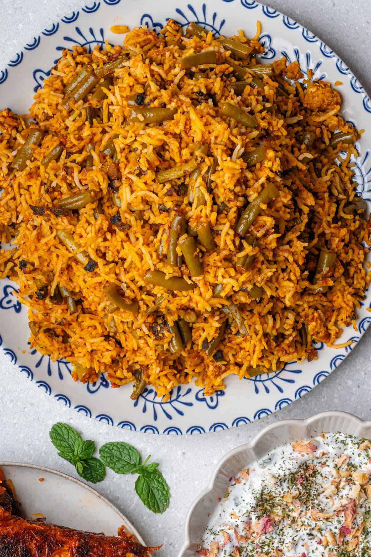Lubia Polo (Persian Green Bean Rice) served with a yoghurt and cucumber dip on the side