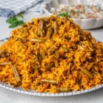 Lubia Polo, Persian Green Bean Rice served on a plate with Mast o Khiar on the side