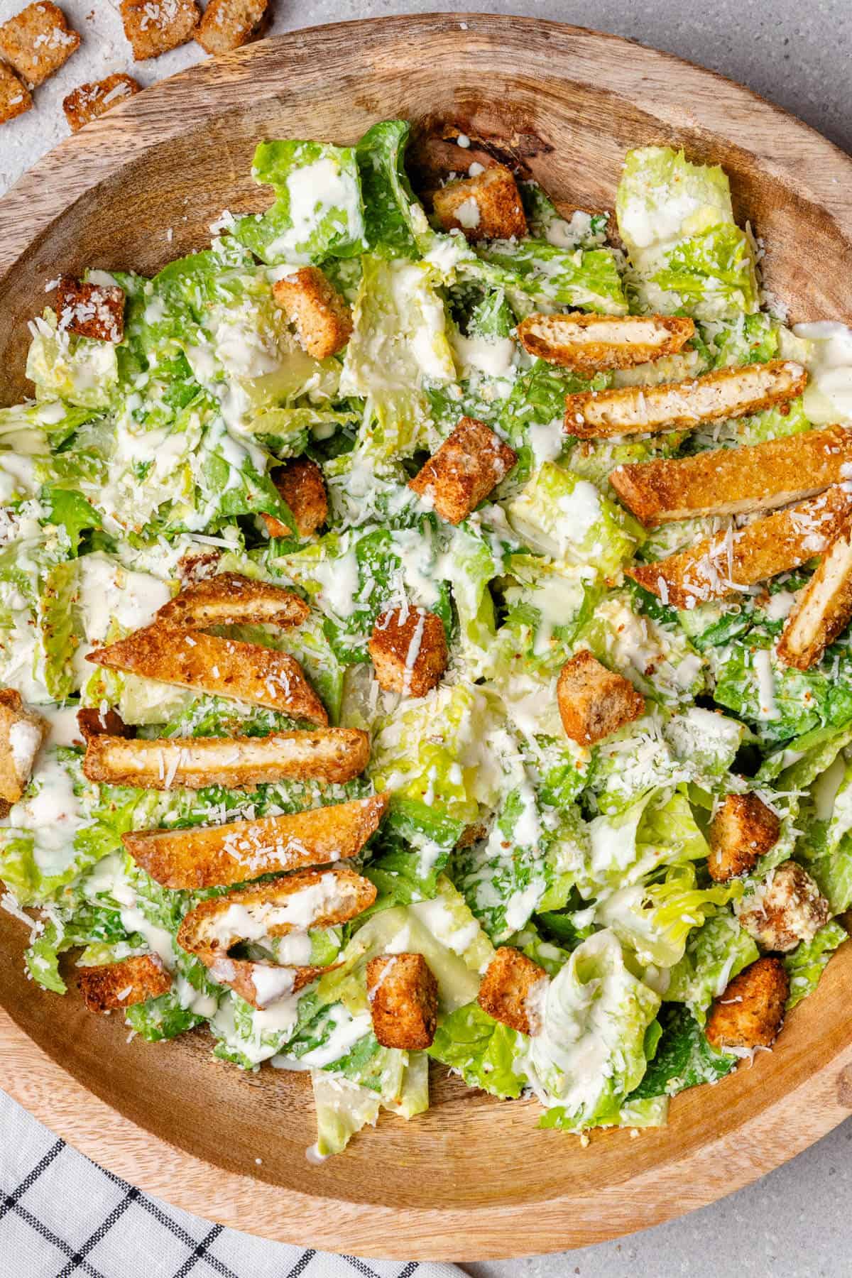 Healthy caesar salad in a bowl topped with breaded tofu