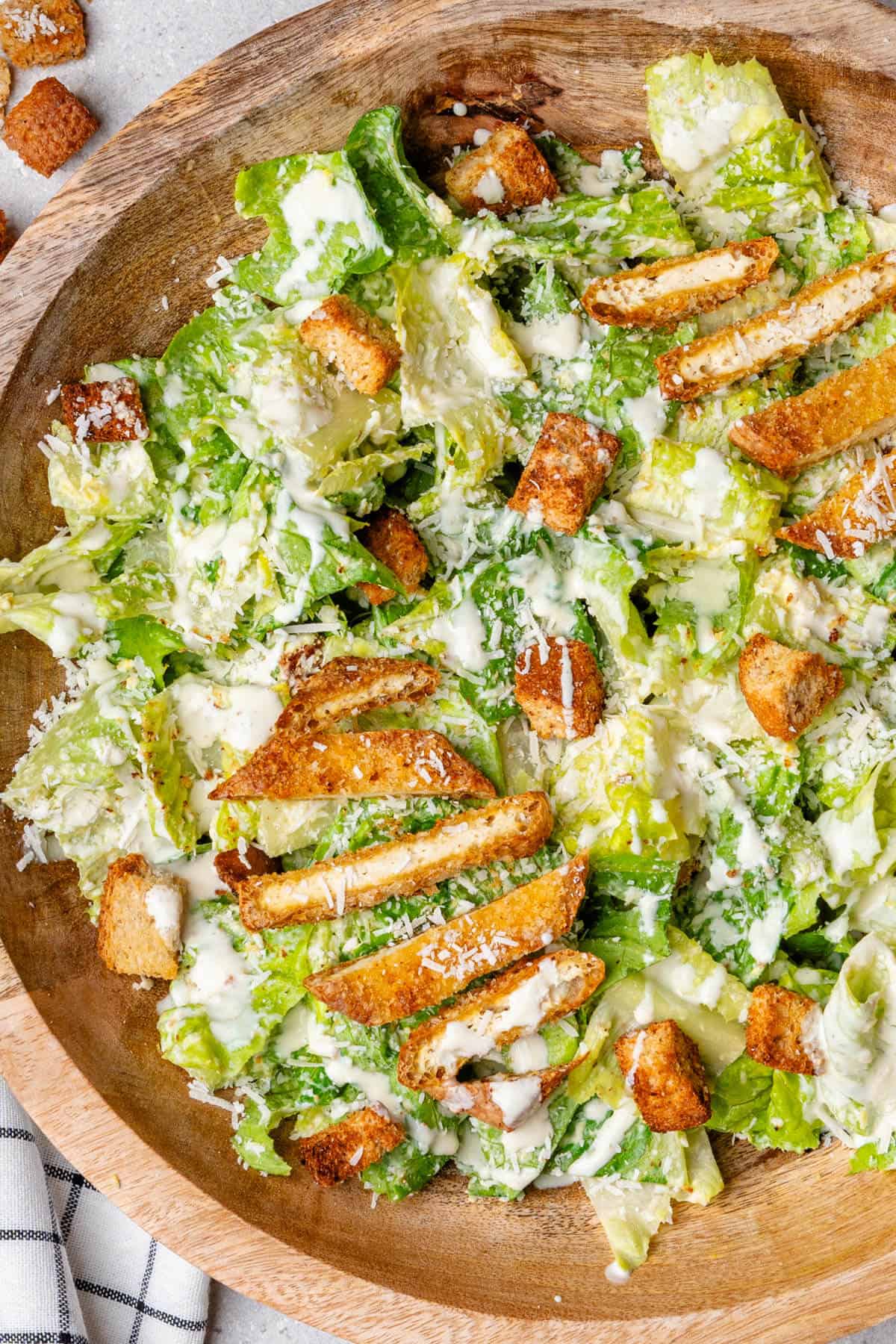 Caesar salad in a bowl topped with breaded tofu