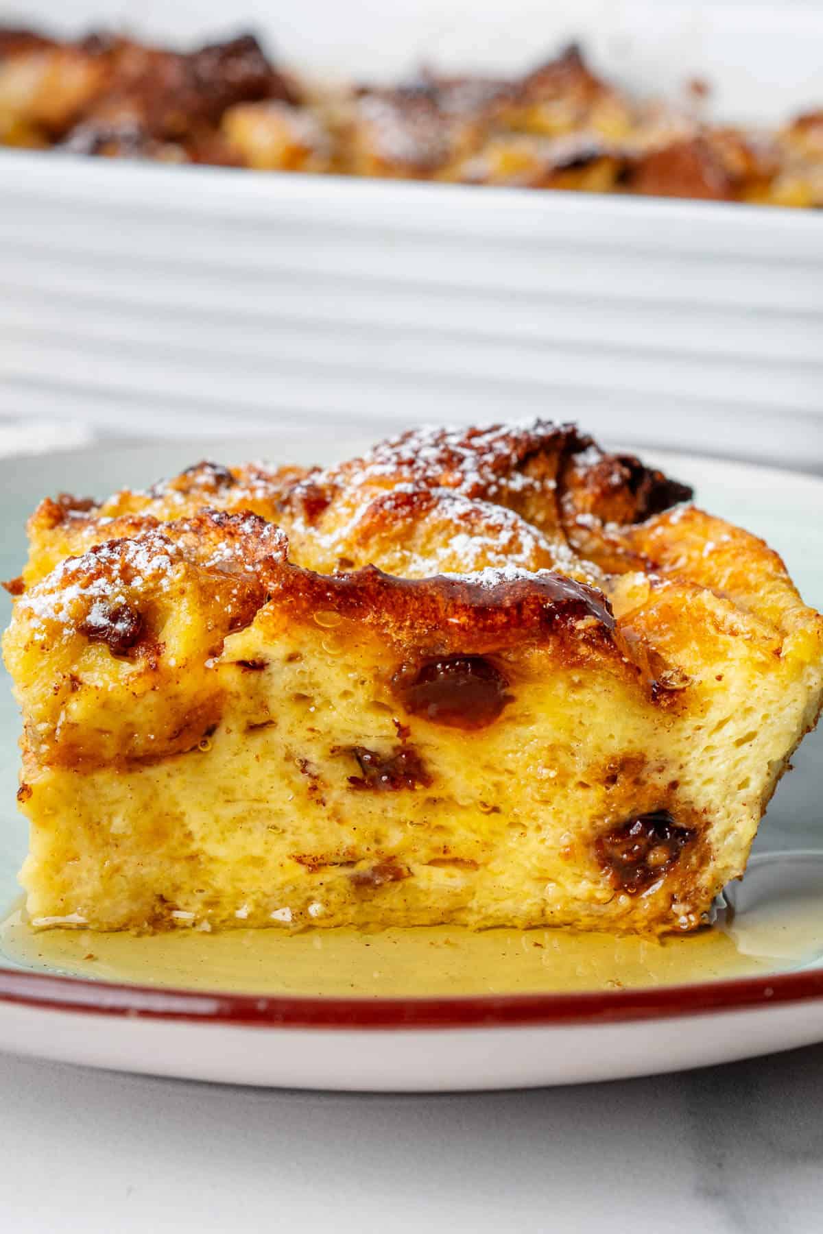 Close up of a piece of Panettone bread pudding topped with maple syrup