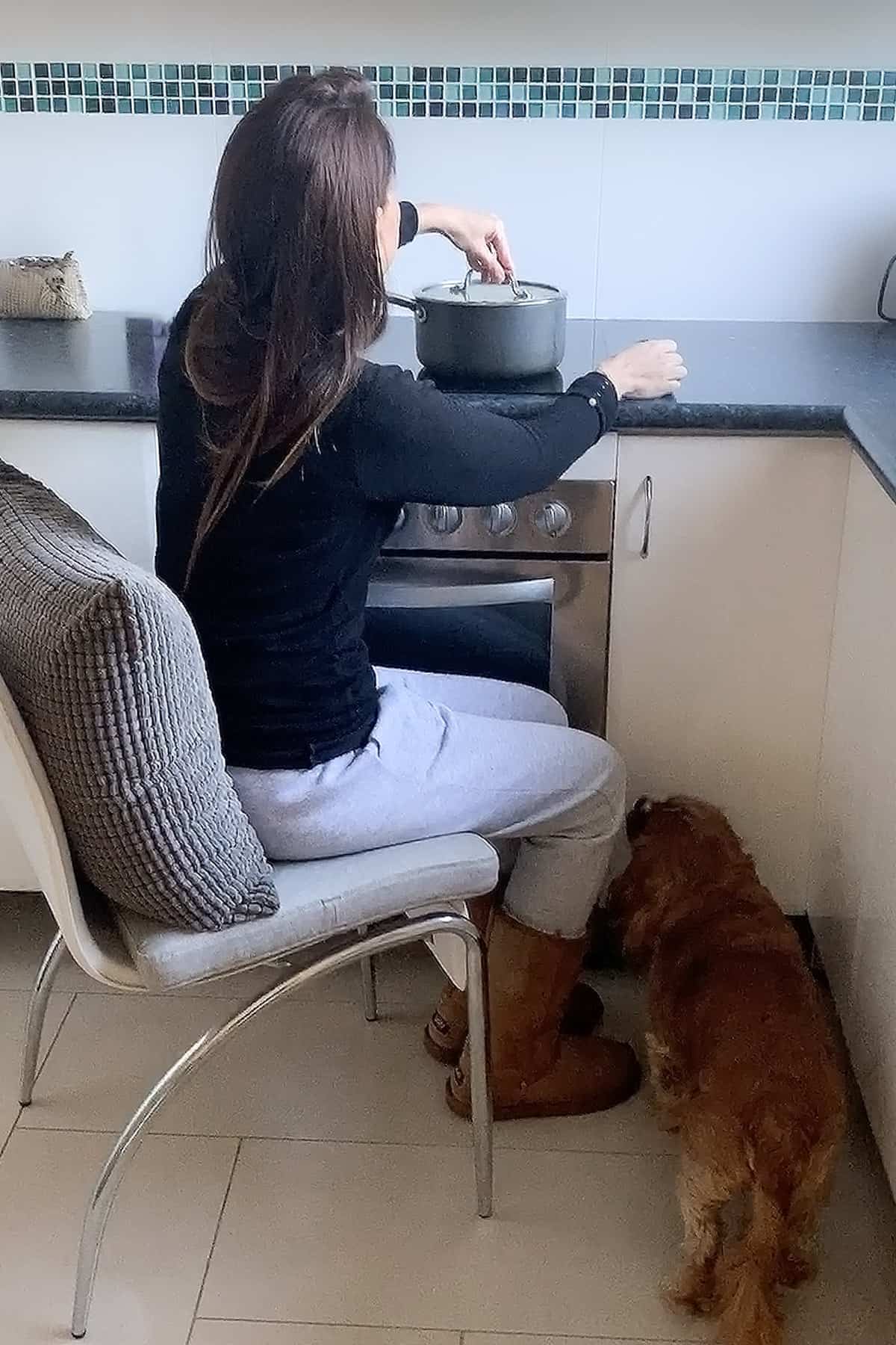Ayeh sitting on a chair whilst cooking in the kitchen