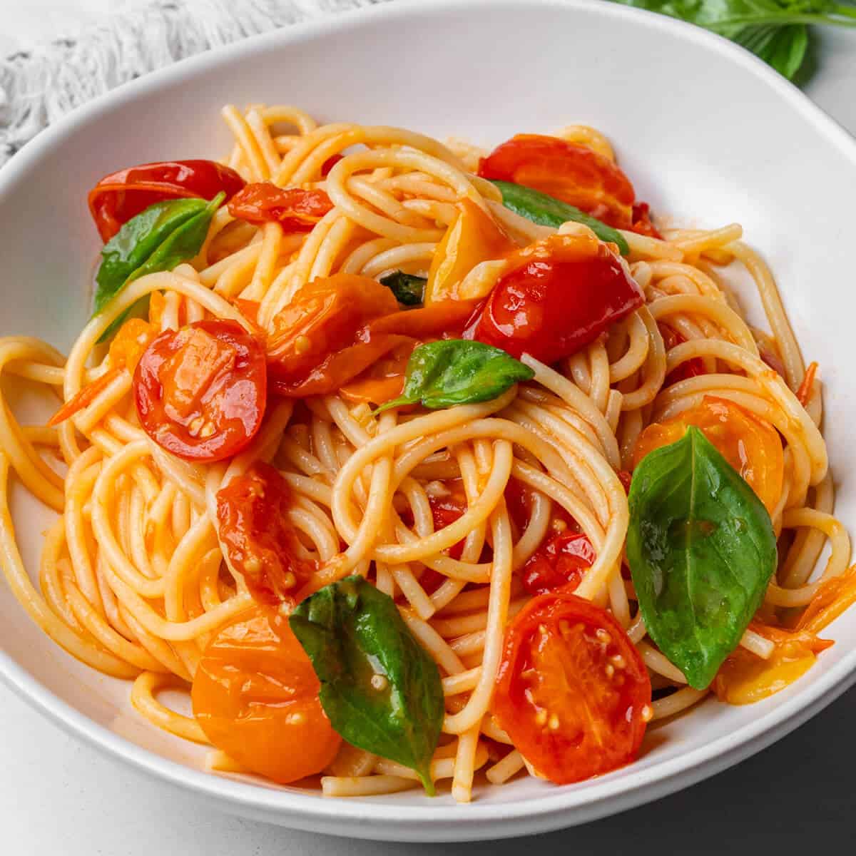 cherry tomato pasta served in a bowl with fresh basil