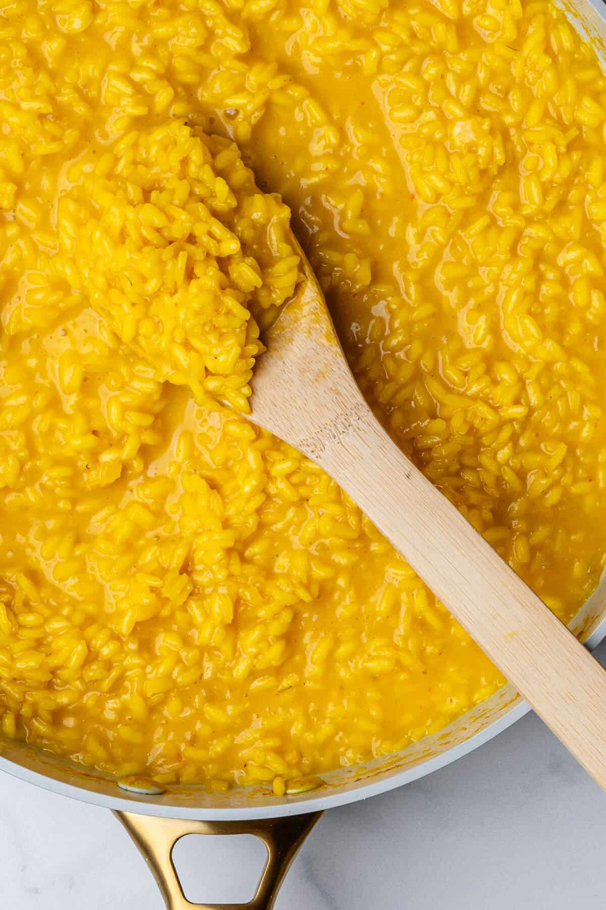 Wooden spoon in a pan of Saffron Risotto