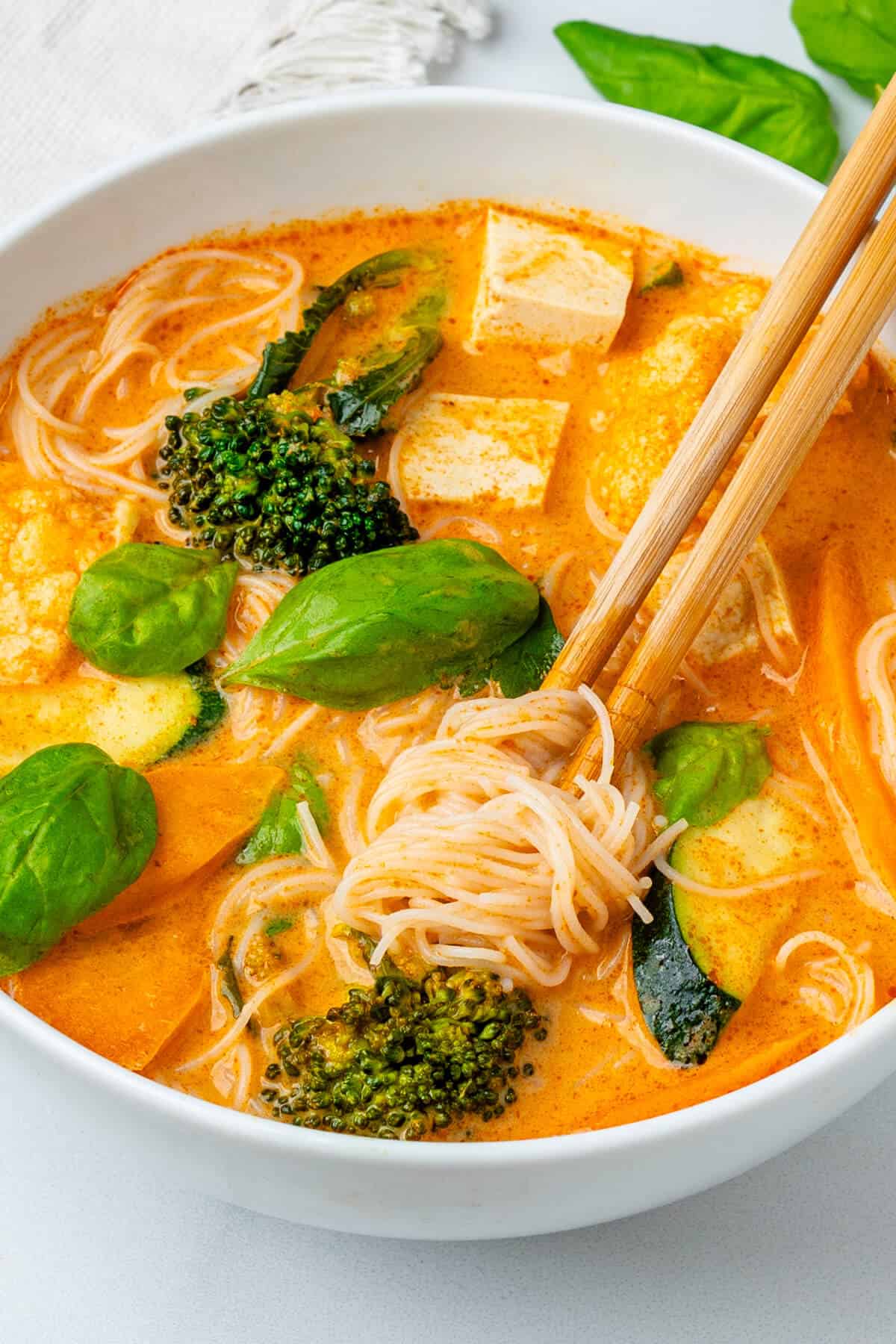 Chop sticks in a bowl of Thai Red curry Soup